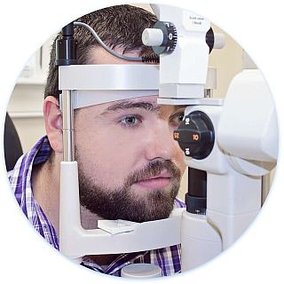 Man behind slit lamp getting an eye exam